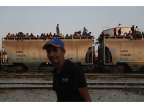 FILE - In this April 23, 2019 file photo, Central American migrants ride a freight train on their way to the U.S.-Mexico border, in Ixtepec, Oaxaca state, Mexico. Mexico President Andrés Manuel López Obrador said on Monday, May 20,2019 that U.S. support for economic development in Mexico and Central America is the best option for stemming the flow of immigrants, meanwhile the U.S. and Mexico are discussing an arrangement under which the U.S. government would guarantee some $10 billion in development investments for Mexico and Central America.