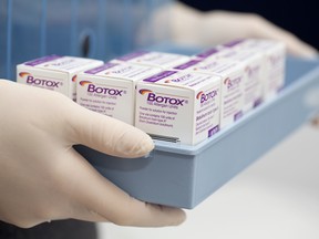 A clinical technician holds a tray of Allergan Botox boxes, produced by Allergan Inc.