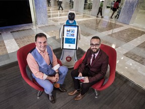 Silvio Stroescu, left, and Financial Post's Victor Ferreira, with one of BMO's wandering robots, BILi.