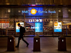 A pedestrian walks past a BMO Harris Bank  branch on the ground floor of the company's headquarters in Chicago, Illinois.