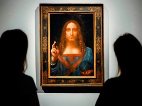 Christie's employees pose in front of the painting entitled Salvator Mundi by Leonardo da Vinci at Christie's auction house in London before it was sold in 2017.