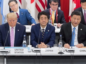 U.S. President Donald Trump sits with Japan's Prime Minister Shinzo Abe, centre, and China's President Xi Jinping as they attend a meeting on the digital economy at the G20 Summit in Osaka on June 28, 2019.