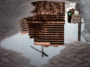 A condominium under construction in Toronto, reflected in a puddle.