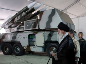 Iran's Supreme Leader Ayatollah Ali Khamenei is seen near a "3 Khordad" system which is said to had been used to shoot down a U.S. military drone, according to news agency Fars, in this undated handout picture.