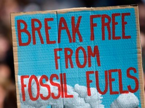 Climate activists protest with a placard reading "break free from fossil fuels" at a rally in Cologne last month. Despite the push to decarbonize and use less energy, investment dollars into these objectives hasn’t budged much in a decade, writes Peter Tertzakian.