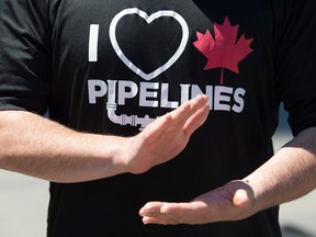 A man wearing an "I love Canadian pipelines" shirt applauds during a pro-pipeline gathering in downtown Vancouver, Tuesday.