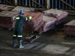 A worker stacks copper plates during the treatment process at the Nchanga copper mine, operated by Konkola Copper Mines, a subsidiary of Vedanta Resources.