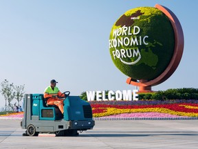 A cleaner drives a sweeper-scrubber past a flower installation for the  Davos meeting by the World Economic Forum (WEF) in Dalian, Liaoning province, China June 11, 2019.
