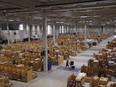 Employees fulfil orders from boxes and parcels stacked in bays ahead of shipping from an Amazon.com fulfilment centre during the online retailer's Prime Day on Mon., July 15.