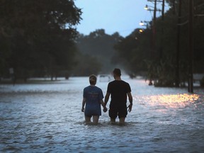 A couple walk down a flooded street in Louisiana in the aftermath of Hurricane Barry.