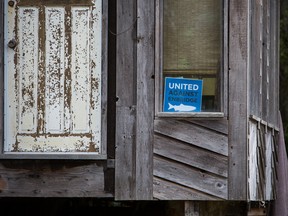 A sign that reads "United Against Enbridge" is displayed in a window in the First Nations village of Old Massett, British Columbia, Canada, on Friday, Aug. 26, 2016.