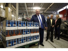 As the Ontario government prepares to move ahead with its plans to overhaul the province's 92-year-old beer distribution system, experts say it should heed lessons from retail sales systems in other provinces. Ontario Premier Doug Ford slaps the top of boxes of beer as Ontario Finance Minister Vic Fedeli laughs in background at a brewery in Etobicoke, Ont., Monday, Aug. 27, 2018.