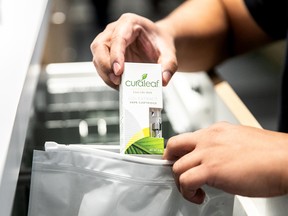 An employee puts a vape cartridge in a bag at a Curaleaf store.