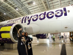In this file photo taken on August 25, 2017, Saudi employees of the new Flydeal airlines company take a selfie during the launching ceremony held at the King Abdulaziz airport in the coastal city of Jeddah.
