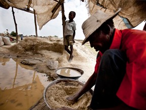 A villager uses mercury and water to search rock powder for gold particles gathered from rocks at the North Mara mine in Mrito, Tanzania.