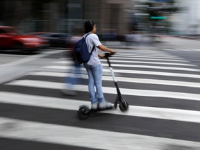 A man speeds though a crosswalk on a Bird scooter in Los Angeles, California.
