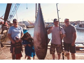 Tuna fishermen pose with their catch in a handout photo.A tuna buyer in Prince Edward Island has opened Canada's first federally licensed plant to process bluefin tuna for the world sushi market.