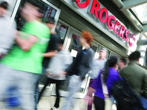 People pass a Rogers store on Yonge Street in Toronto.