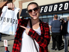 A customer shows off her purchase during the opening at the Premium Four20 Market in Calgary last October.
