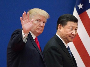 This file picture taken on November 9, 2017 shows U.S. President Donald Trump (L) and China's President Xi Jinping leaving a business leaders event at the Great Hall of the People in Beijing.