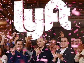 Confetti falls as Lyft CEO Logan Green, centre, and President John Zimmer, left centre, ring the Nasdaq opening bell celebrating the company's initial public offering on March 29, 2019 in Los Angeles, California. The ride hailing app company's shares initially priced at US$72 are now trading at US$41.05.