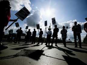 Demonstrators holds during a United Auto Workers (UAW) strike outside the General Motors Co. Flint Assembly plant in Flint, Michigan, U.S., on Monday, Sept. 16, 2019.