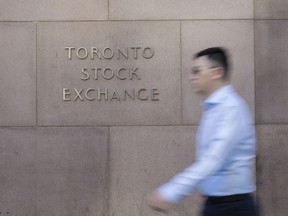 A pedestrian walks past the Toronto Stock Exchange in the financial district of Toronto.
