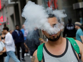 A man uses a vape as he walks on Broadway in New York City.