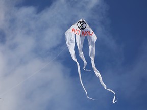 A kite with the extinction symbol flies in the sky as Extinction Rebellion demonstrators block the Muhlendamm Bridge during the launch of a new wave of civil disobedience in Berlin, Germany October 9, 2019.