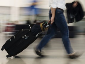 A traveler pulls luggage through Toronto Pearson International Airport. Airline fares soared 10.3 per cent in August year-over-year after rising 4.6 per cent in July, according to the Statistics Canada.