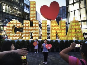 Chinese children have their picture taken in front of a large sign set up for national day and Golden Week holidays in Beijing.