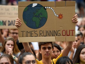 A demonstrator holds a placard reading "time is running out" during a global youth climate action strike in Barcelona, on September 27, 2019 at the end of a global climate change week.