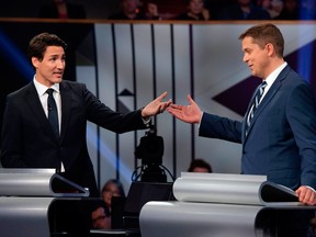 Conservative leader Andrew Scheer, right, and Prime Minister and Liberal leader Justin Trudeau gesture to each other as they both respond during the Federal Leaders Debate at the Canadian Museum of History in Gatineau, Quebec on October 7, 2019.