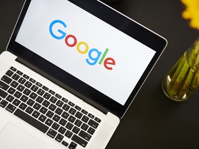 The Google logo on an Apple laptop.