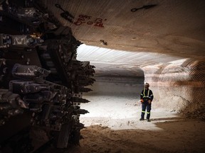 A miner stands near the cutting head of a digger near an active mining wall at the Nutrien Ltd. Cory potash mine in Saskatoon, Saskatchewan.