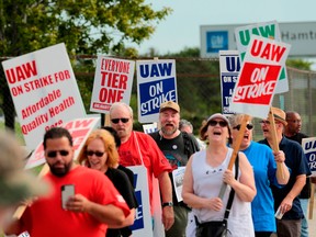 In this file photo taken on September 22, 2019 Members of the United Auto Workers (UAW) and supporters picket outside of General Motors Detroit-Hamtramck Assembly in Detroit, Michigan.
