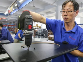 A worker produces desks for export to the U.S., France, Germany and other countries, at a factory in Nantong in China's eastern Jiangsu province. The World Trade Organization slashed its forecast for trade growth Tuesday.