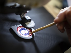 An employee arranges a logo patch in a sewing machine at the new Canada Goose Inc. manufacturing facility in Montreal.