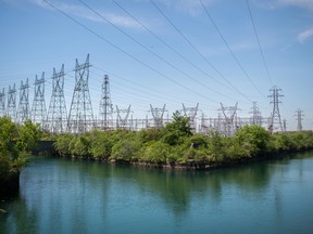 Power lines hang from transmission pylons above a reservoir at the Ontario Power Generation Inc. Sir Adam Beck Generating Station along the Niagara River in Niagara Falls, Ontario.