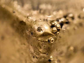 Surface bubbles on a newly cast bar of gold.