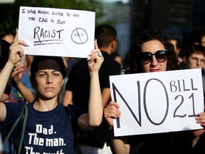 People protest Quebec's new Bill 21, which bans teachers, police, government lawyers and others in positions of authority from wearing religious symbols such as Muslim head coverings and Sikh turbans, in Montreal in June.