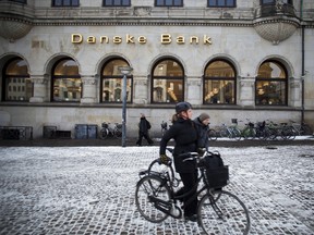 Cyclists pass a Danske Bank A/S branch in Copenhagen, Denmark.