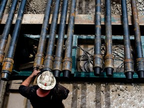 A drill hand prepares drill pipe as a shale-gas well is drilled in Mannington, West Virginia.