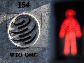 A red pedestrian light is seen next to the entrance of the headquarters of the World Trade Organization. The 164-member body is losing its ultimate referee on trade at the worst possible time.