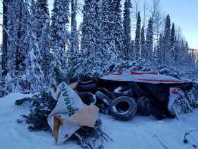 A stack of tires with jugs of gasoline covered by tarps and trees is showing in this photo from the RCMP.