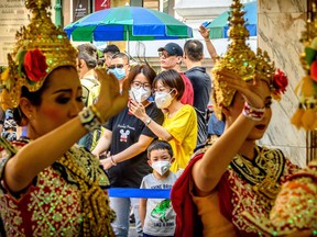 Tourists with face masks watch a traditional Thai dance at Erawan shrine, a popular spritual landmark in Bangkok on January 27, 2020.  Thailand has detected eight Coronavirus cases so far.