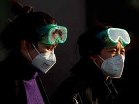Travellers wearing facemasks arrive from various provinces at the Beijing Railway Station on February 3, 2020.