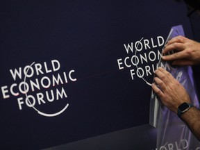 A worker applies a transfer on the wall inside the Congress Center ahead of the World Economic Forum (WEF) in Davos, Switzerland, on Monday, Jan. 20, 2020.