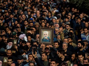 Protesters hold up an image of Qassem Soleimani, an Iranian commander, during a demonstration following the U.S. airstrike in Iraq which killed him, in Tehran, Iran, on Friday, Jan. 3, 2020.