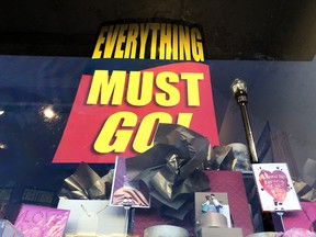 A sign stating "everything must go" is posted next to a window display at a Papyrus store in California.